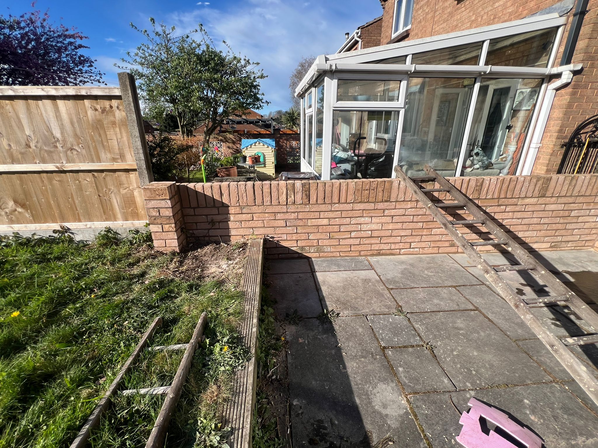Completed patio and boundary wall works beside conservatory