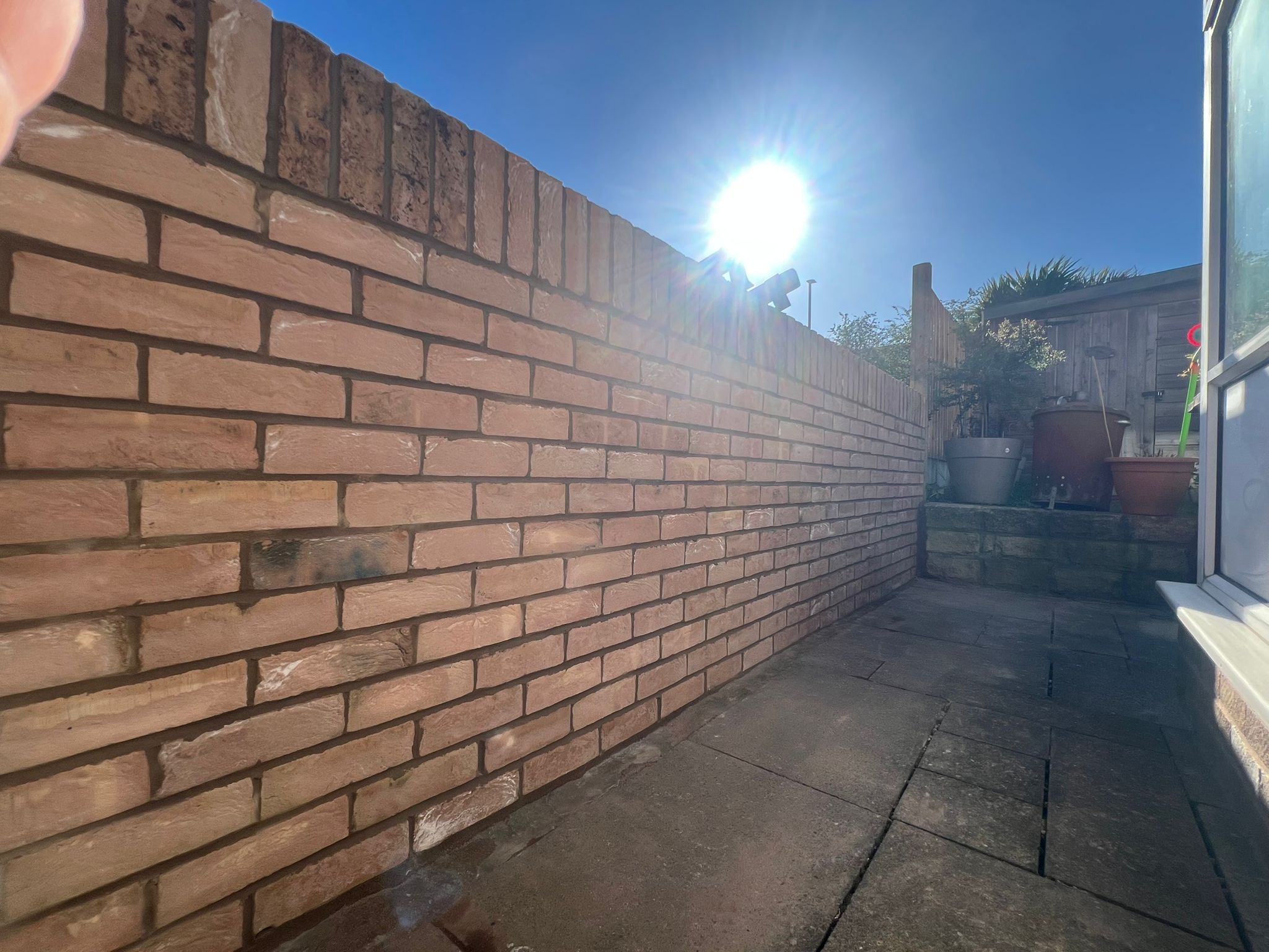 Finished brick boundary wall running alongside paved access