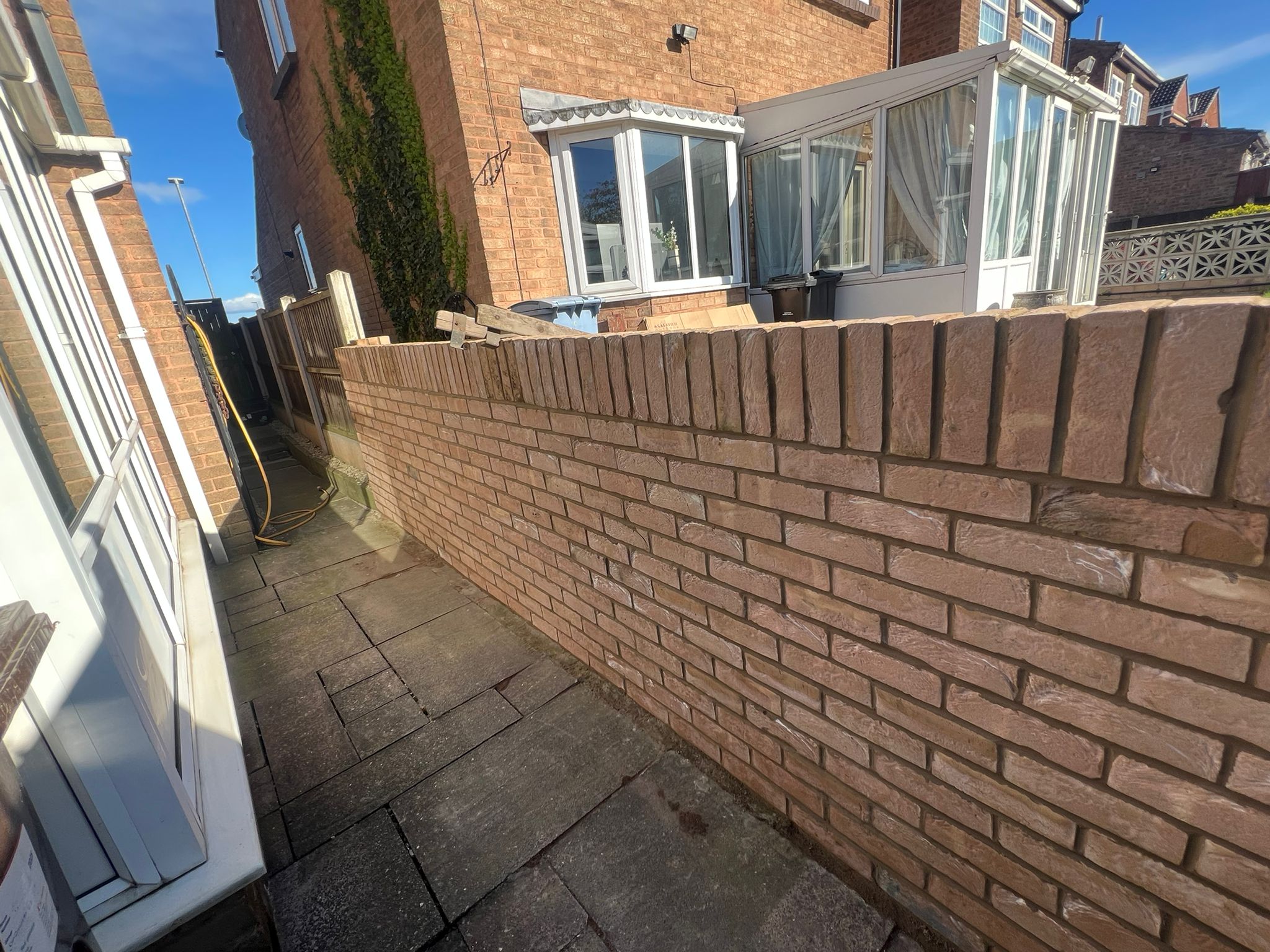 Side elevation showing completed boundary wall and conservatory
